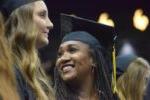 woman wearing black graduation cap smiles during the ceremony
